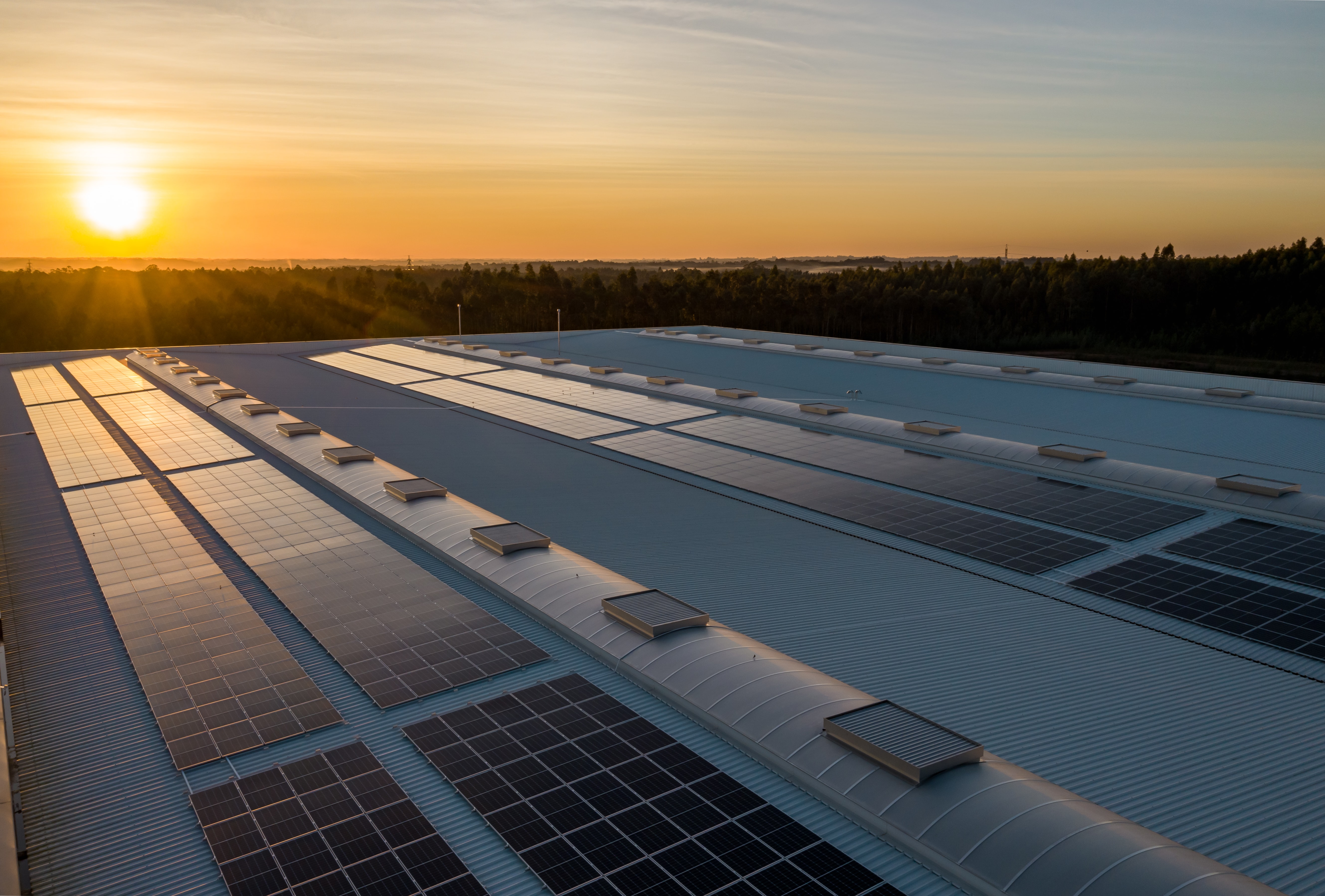 Roof mounted solar panels on an industrial unit at sunset