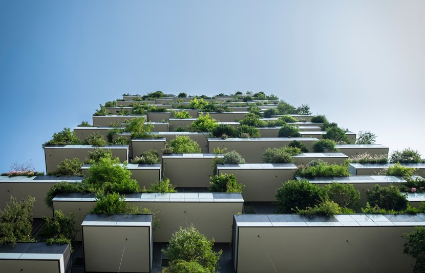An upward view of apartment block with staggered green planting