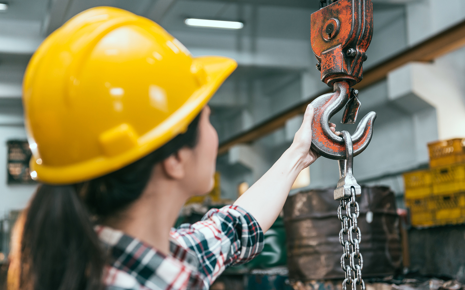 Health, safety and risk - woman wearing a hard hat with a crane 