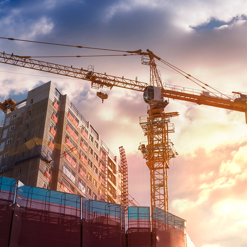 Urban construction crane working on modern skyscraper