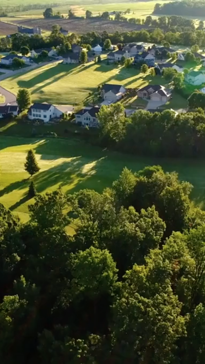 Aerial landscape with housing development surrounded by fields 
