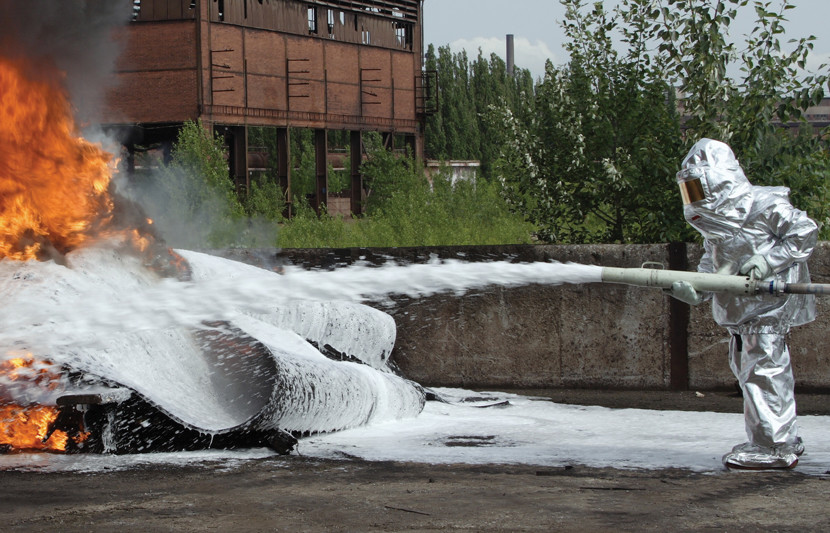 An image of a firefighter extinguishing a blaze. PFAS & PFOS are chemicals given off.