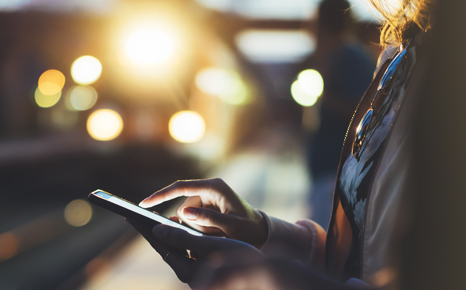 Woman using phone while waiting on railway platform