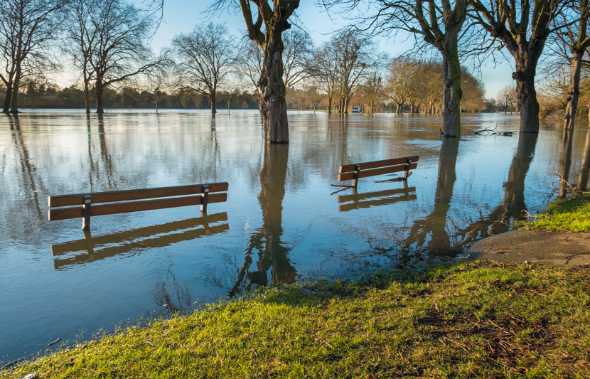 River flooding up embankments and over the top of benches