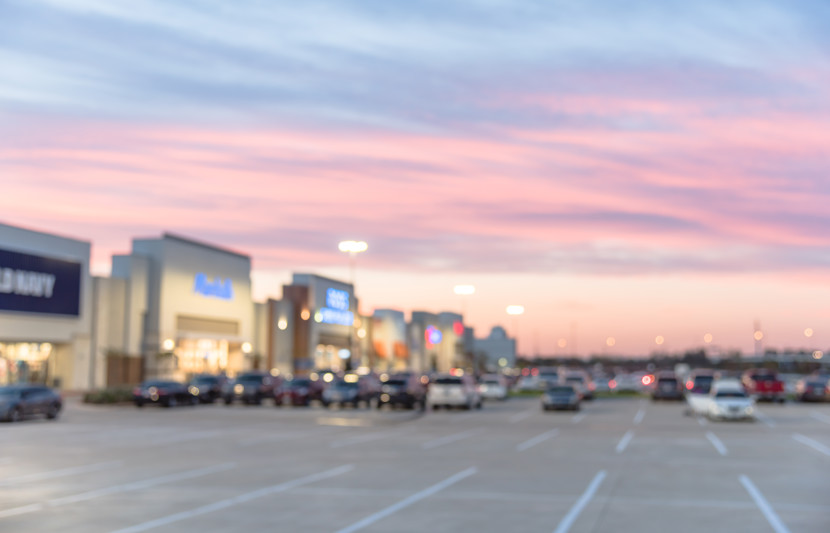 Blurred image of a retail park with a pink sunset