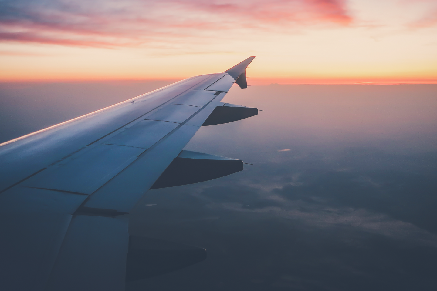 Photo of plane wing taken from inside plane in flight at sunset
