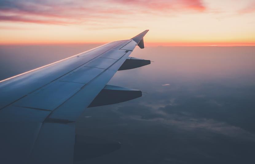 Photo of plane wing taken from inside plane in flight at sunset