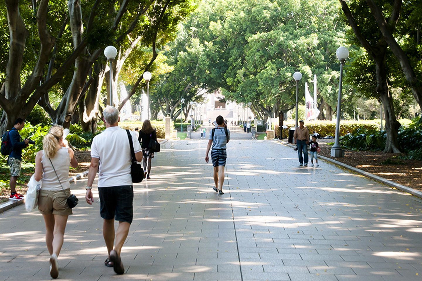 People walking through city park.