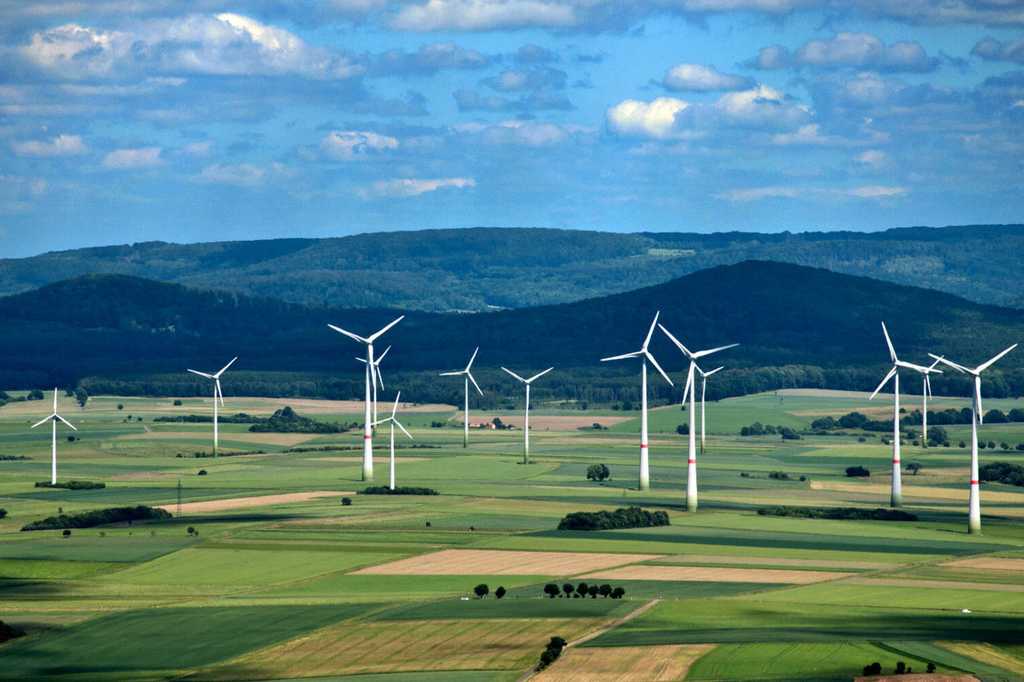 A view of a wind farm in front of mountains