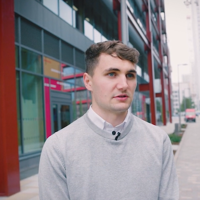 Male employee stood outside office building