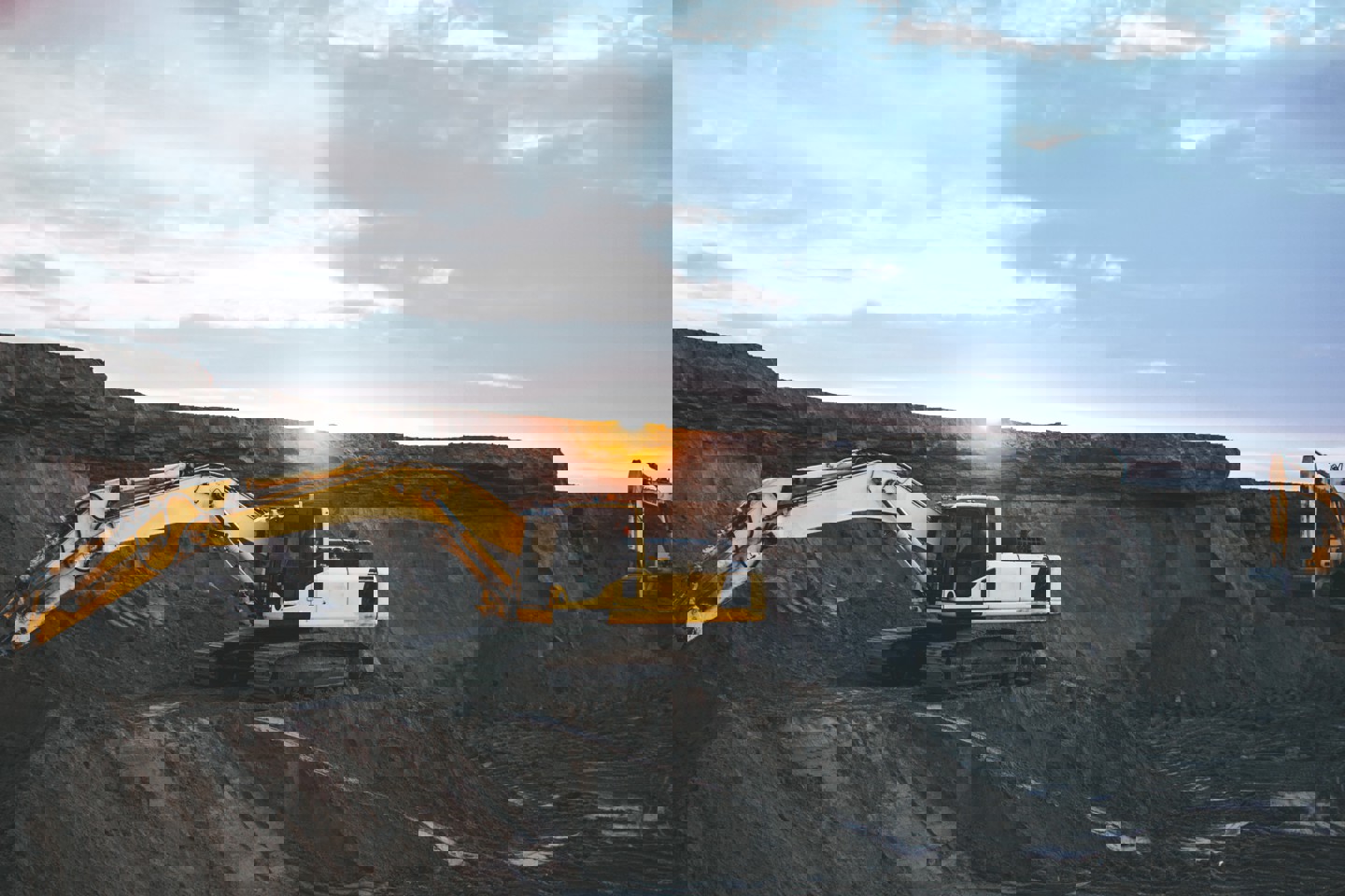 Mineral resource extraction site with yellow digger working on site