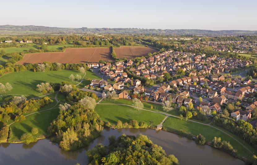 An aerial view of houses and countryside with a river running through