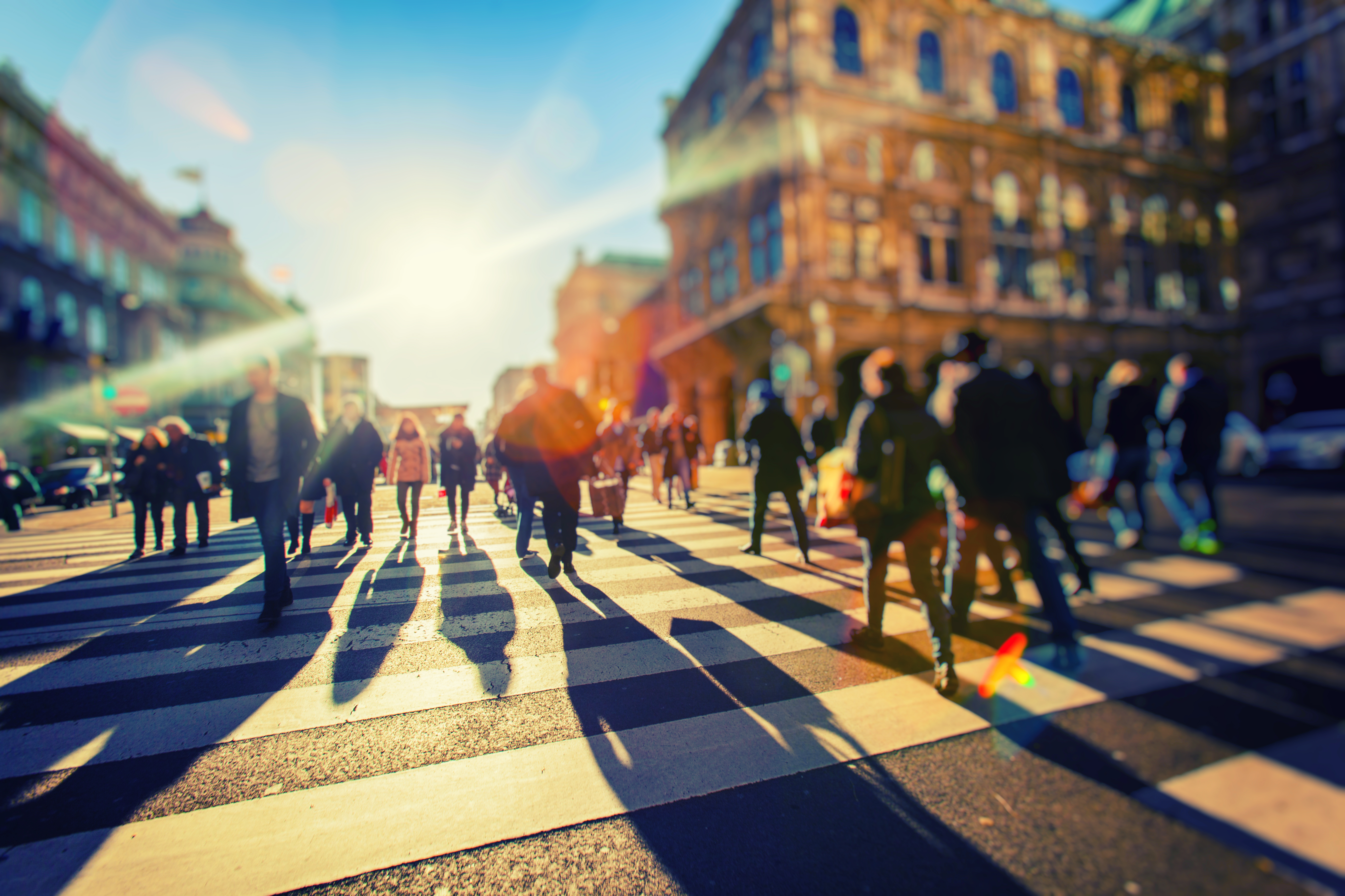 Crowd of people walking on sunny streets