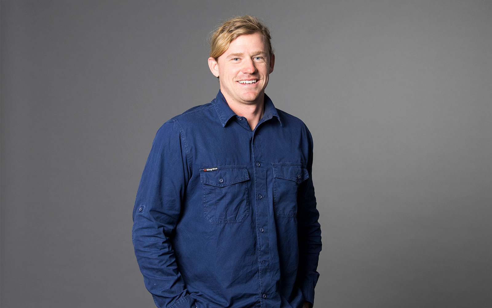 Hugh Jakins,  RPS Senior Surveyor smiles at the camera wearing blue work shirt