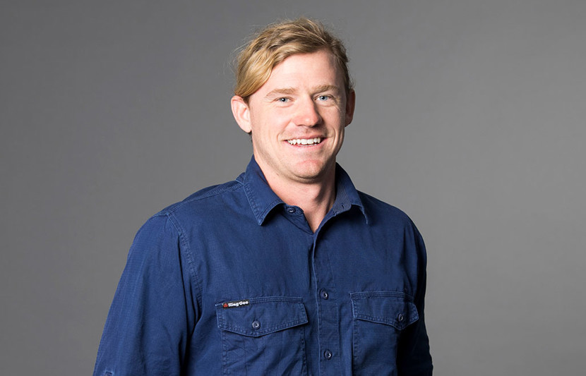 Hugh Jakins, RPS Senior Surveyor smiles at the camera wearing blue work shirt