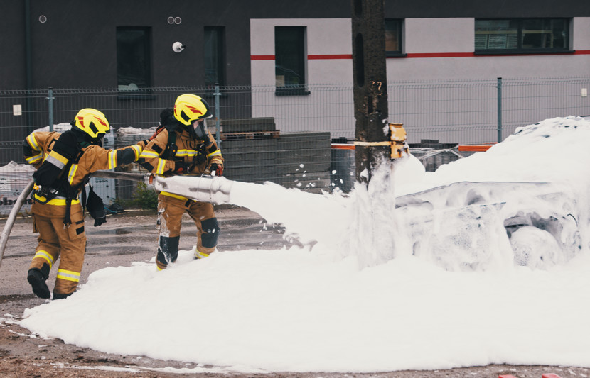 Firefighter using a foam extinguisher to put out a fire. The chemicals used in fire retardant foam include PFAS & PFOS chemicals which are toxic.
