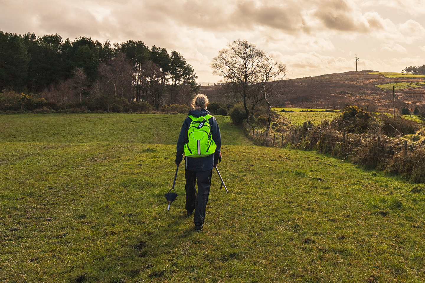 RPS employee in agricultural field walking with back to the camera