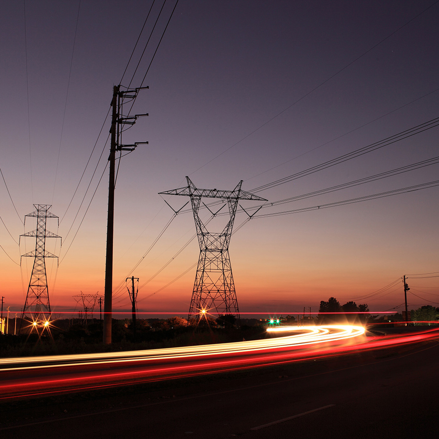 Power transmission lines and road infrastructure at sunset