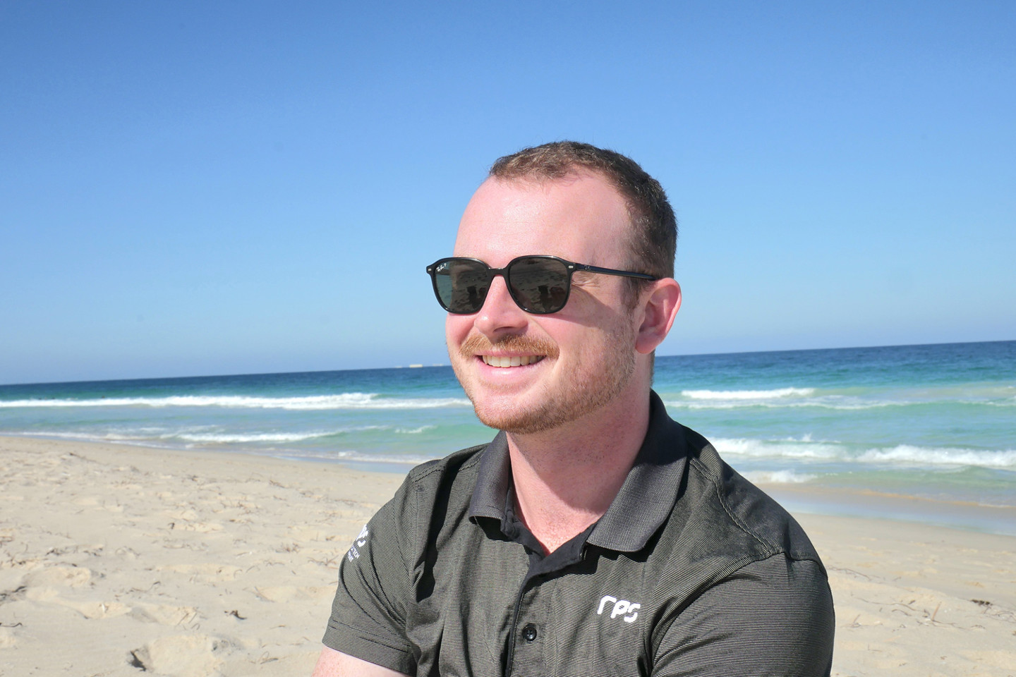 RPS scientist Ciaran Carolan smiles against the backdrop of a sunny Perth beach